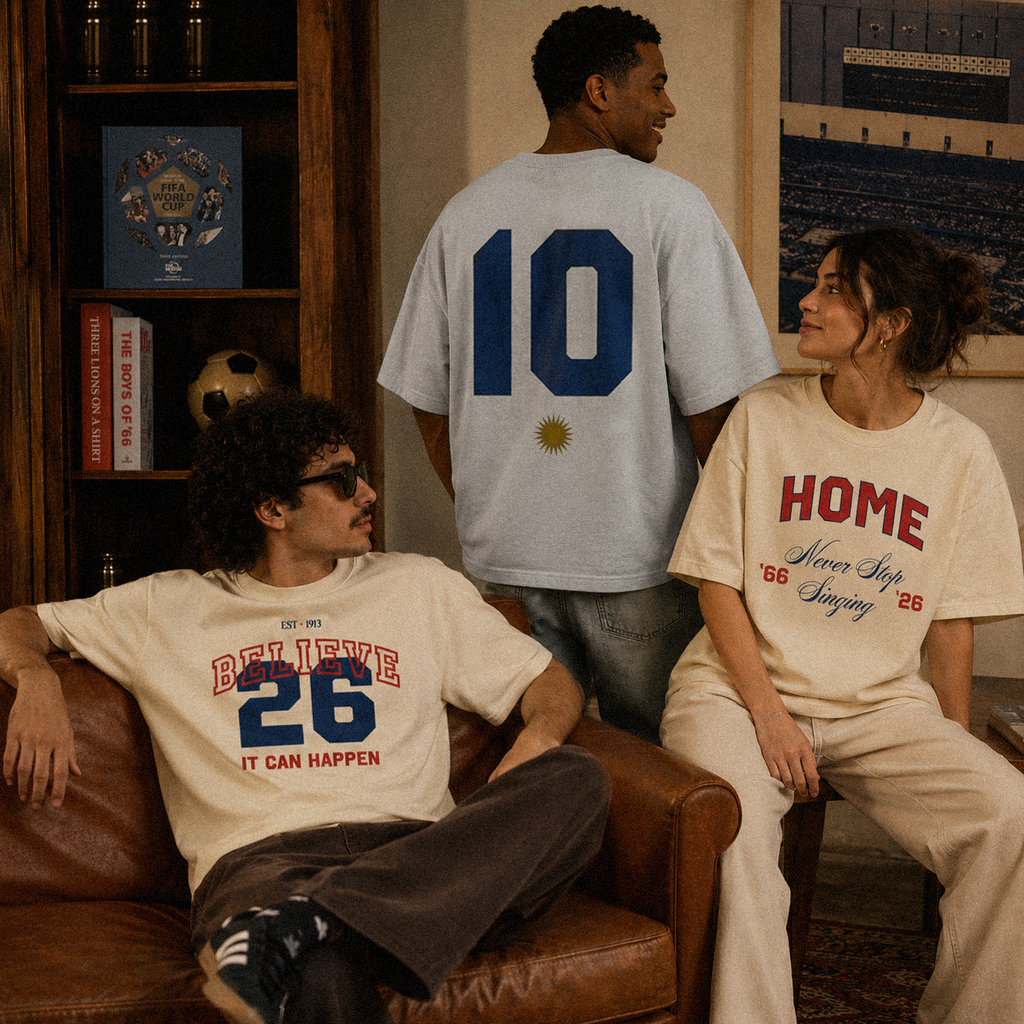 Home tee, cream, three models wearing oversized boxy fit featuring HOME Never Stop Singing, It Can Happen Believe 26, and Argentina number 10 prints, indoor lifestyle shot