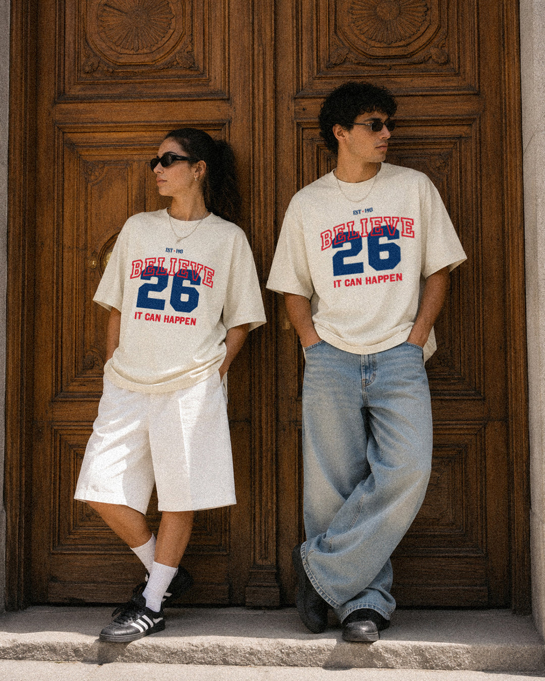It Can Happen tee, cream, man and woman wearing oversized boxy fit showing Believe 26 It Can Happen front print, outdoor editorial lifestyle shot