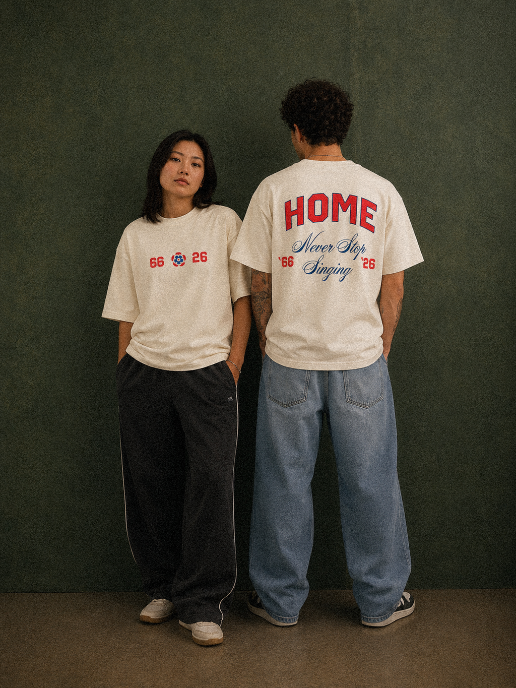 It's Coming tee, cream, man and woman wearing oversized boxy fit showing 66 Three Lions 26 front print and HOME Never Stop Singing back print, green studio lifestyle shot