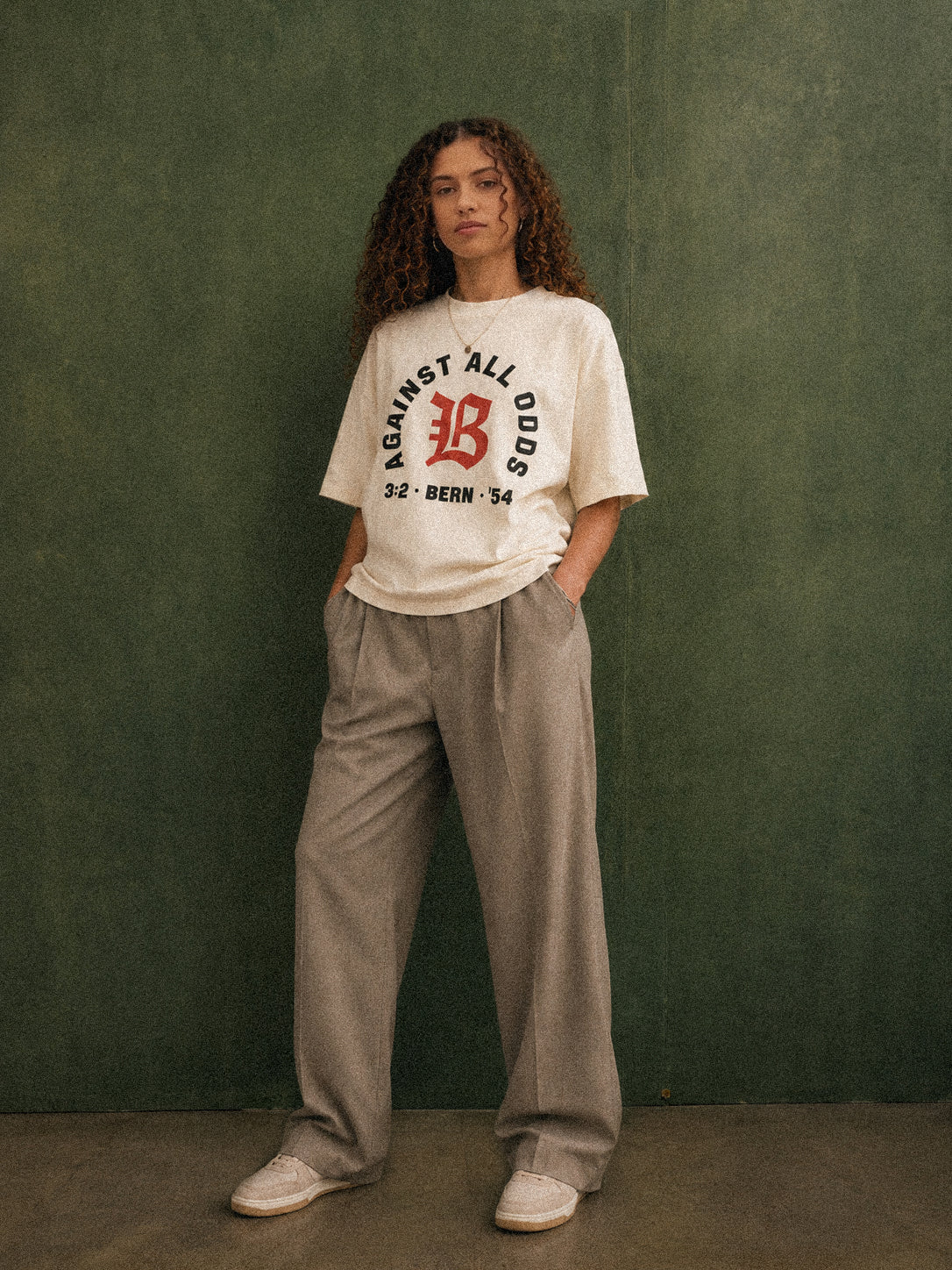 Nobody Believed tee, cream, woman wearing oversized boxy fit showing Against All Odds front print, green studio shot