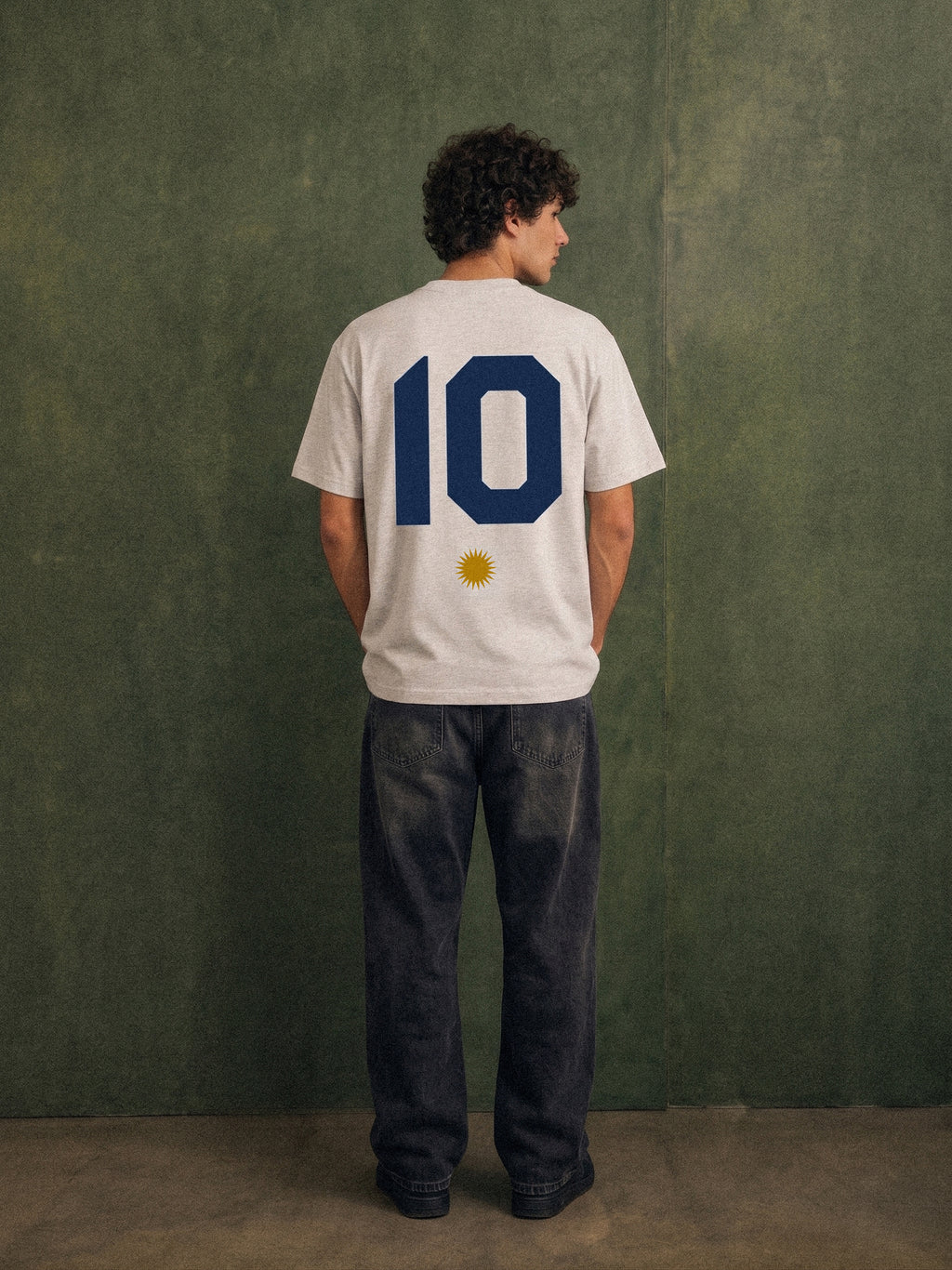 The Greatest Story tee, oat gray, man wearing oversized boxy fit showing Greatest Story Argentina back print, outdoor lifestyle shot