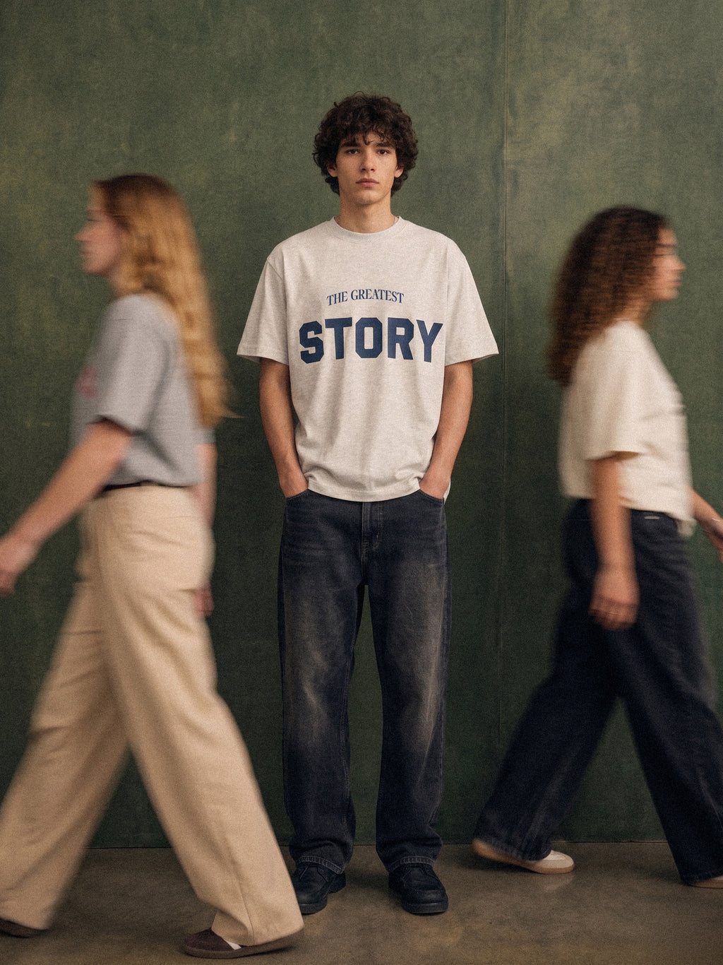 The Greatest Story tee, oat gray, man wearing oversized boxy fit showing Greatest Story number 10 Argentina front print, green studio lifestyle shot